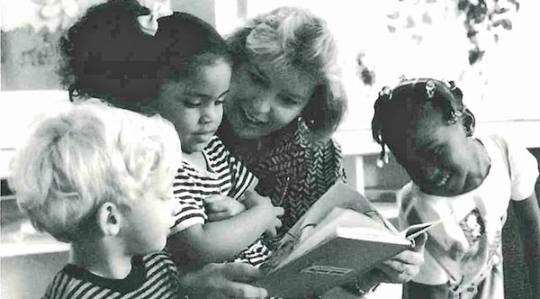 Swann volunteering her time to read to children.