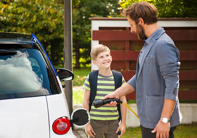 Get a rebate for installing an electric vehicle charger, father and son charging electric vehicle
